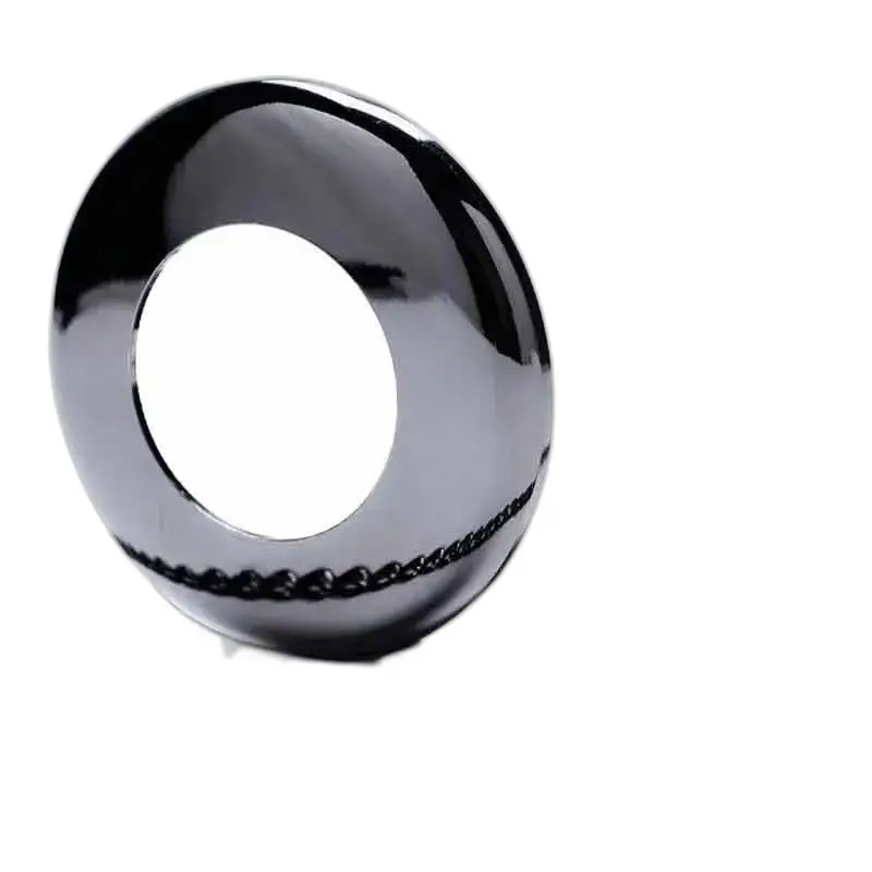 Vase donut noir brillant en harmonie avec une montre à gousset au design unique